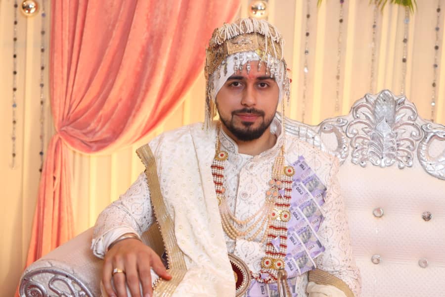 Groom portrait on the wedding stage, detail of the safa and sherwani
