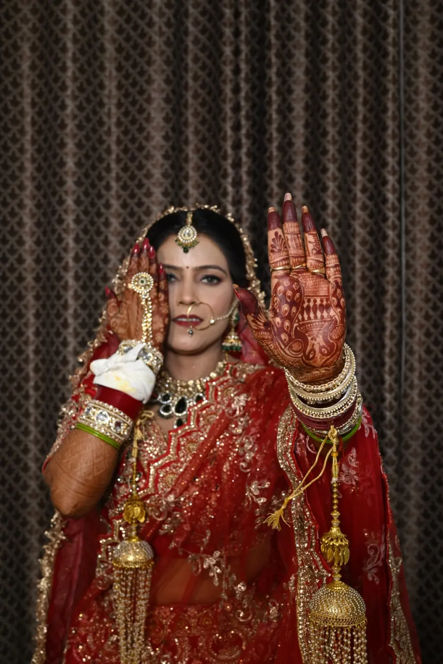 Bride showing off her mehendi against a dark backdrop