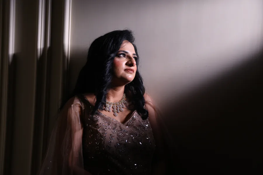 Bride in a shimmering gown, moody window-light portrait