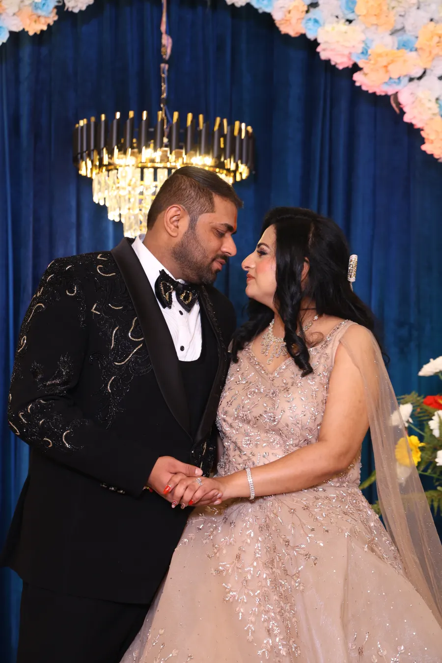 Couple portrait under a floral reception backdrop