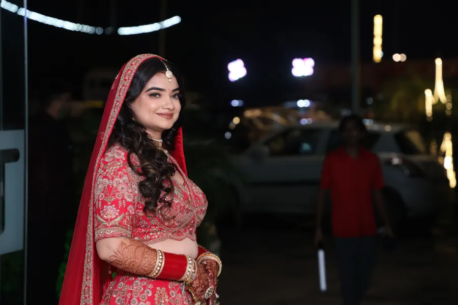 Bride smiling outdoors at night before the ceremony