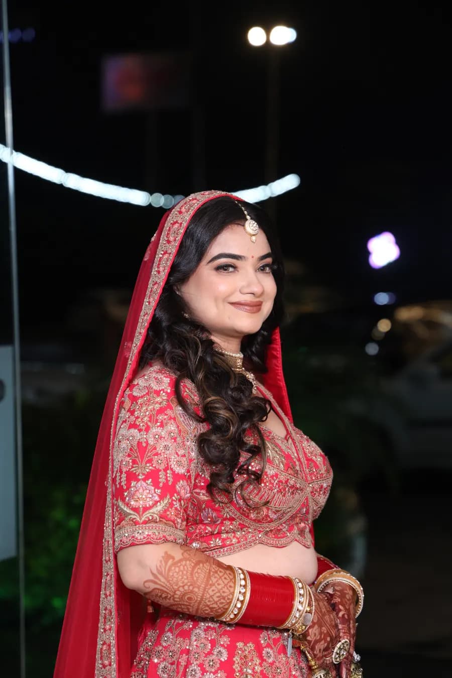 Bride outdoors at night, red dupatta draped over her shoulder