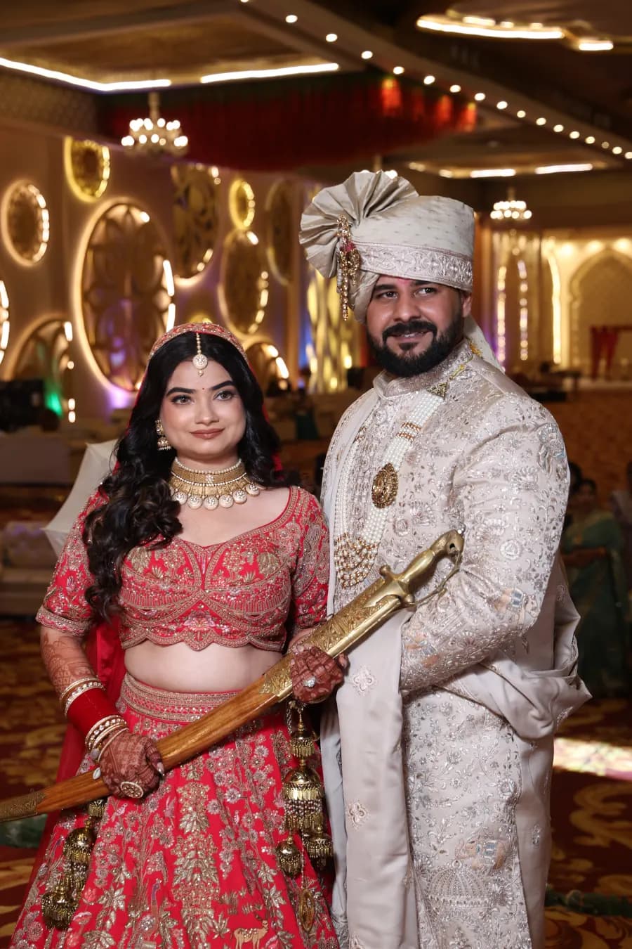 Couple posing with a ceremonial sword at the reception
