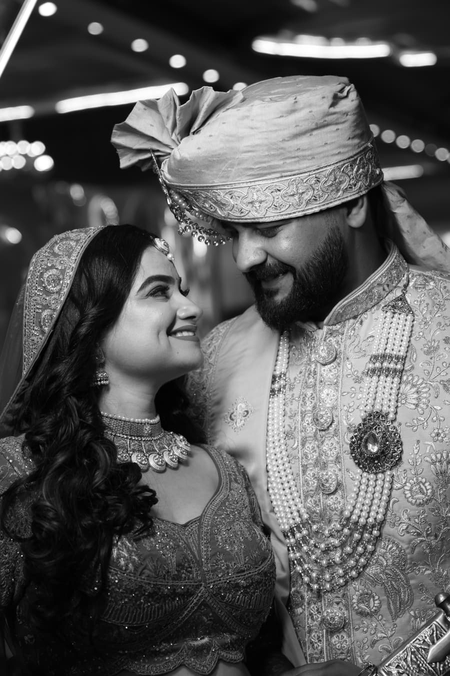 Black-and-white close-up of the couple, foreheads touching