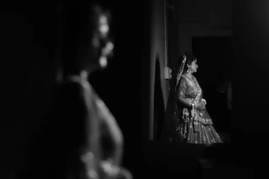 Bride softly lit in the distance, foreground silhouette adds depth