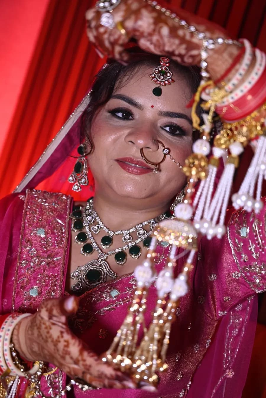 Close-up bridal portrait highlighting the nath and layered jewelry